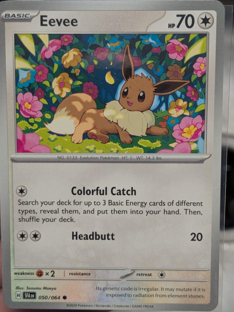 Eevee 050/064 Shrouded Fable card in a flower garden